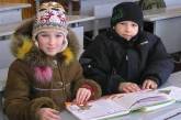 Первый день после школьных каникул: ученики сидят в классах в пальто и шапках