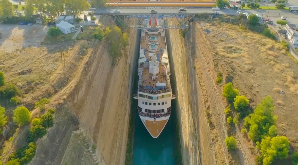 Большой круизный корабль протискивается по узкому каналу в Греции
