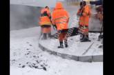 Несмотря на снегопад и пробки в Киеве, коммунальщики укладывают асфальт