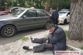 В Николаеве пьяный таксист уснул на тротуаре — в салоне авто нашли наркотики. Видео