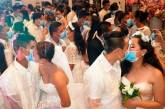 На филиппинской массовой свадьбе пары целовались в защитных масках. ФОТО