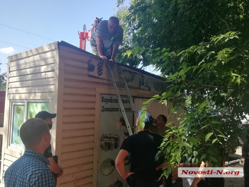 В Николаеве со скандалом сносили киоск: владельцы залезли на будку и провоцировали драку. ВИДЕО