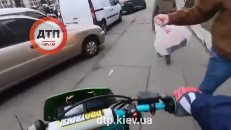 В Киеве пешеход сбил пакетом мотоциклиста, объезжавшего затор по тротуару. ВИДЕО