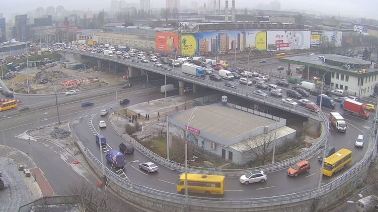 В Киеве на Шулявском мосту на движущийся транспорт упали электроопоры. Видео