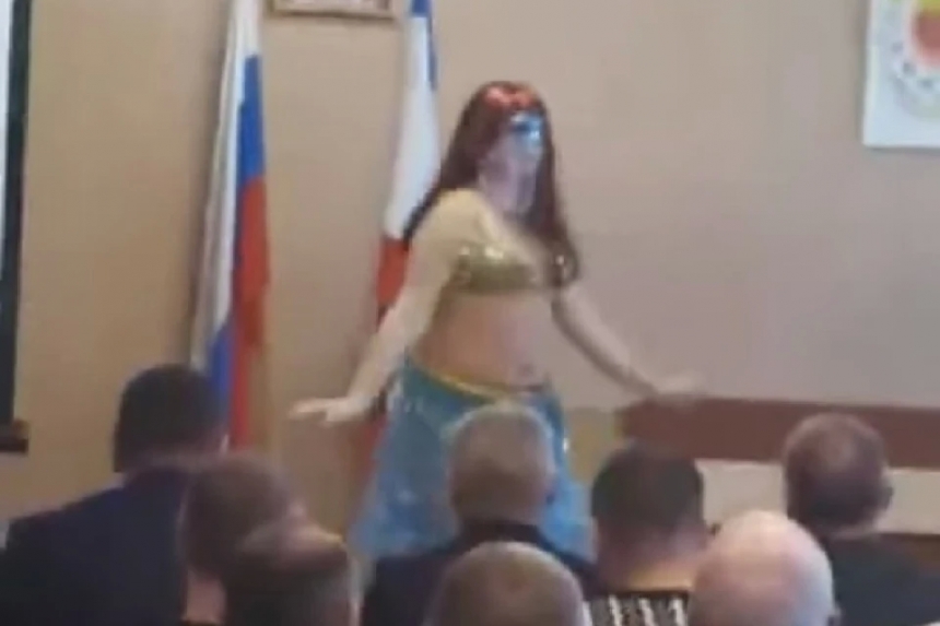 Переодетый мужчина показал танец живота на фоне флага и герба в крымской администрации