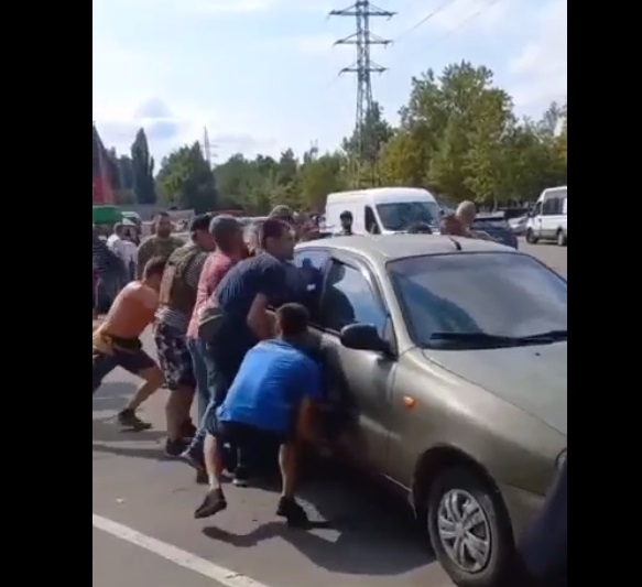 Миколаївці голіруч пересунули «Ланос», який заважав проїзду фури на парковці (відео)