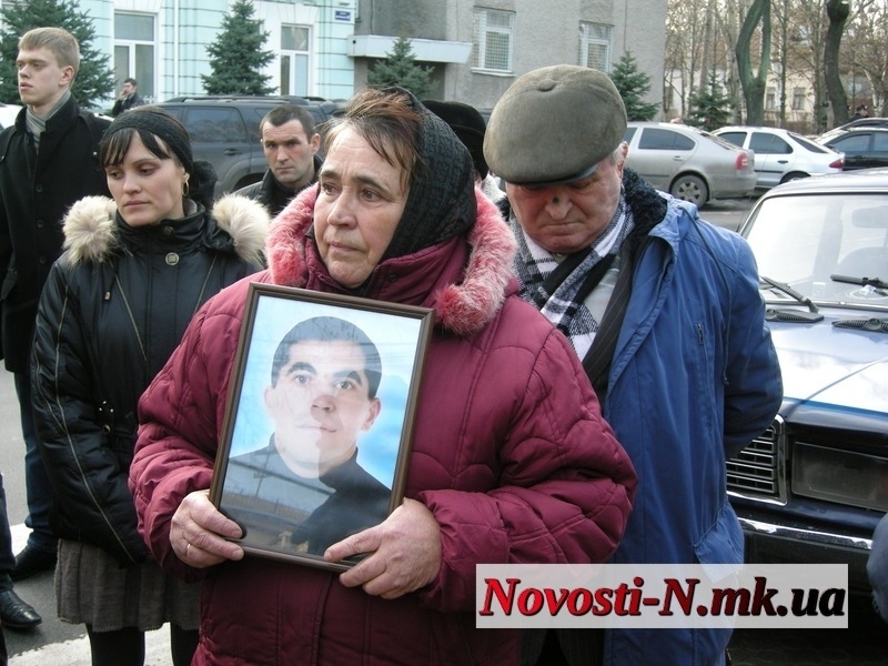 Родители погибшего: мать держит фото сына
