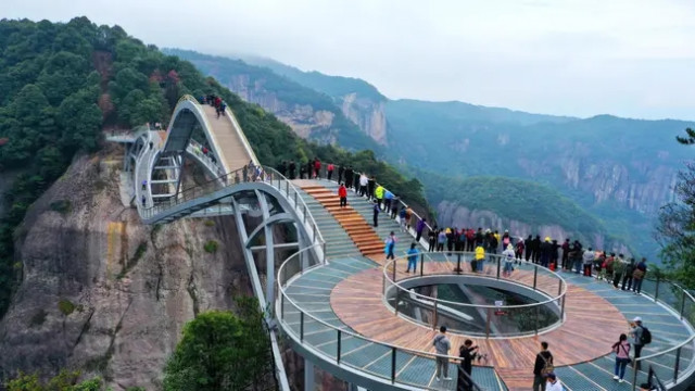 В Китае открылся изогнутый стеклянный мост, построенный на высоте 140 метров (фото, видео)