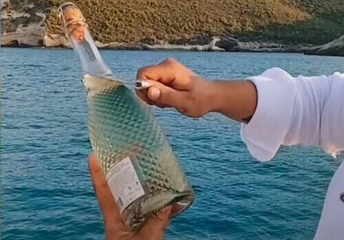 Спробувавши відкрити шампанське, чоловік утопив пляшку в морі (ВІДЕО)