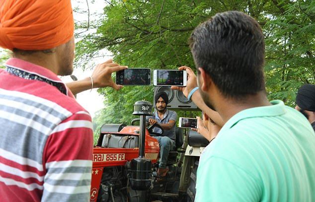 Индийский фермер показывает байкерские трюки на тракторе
