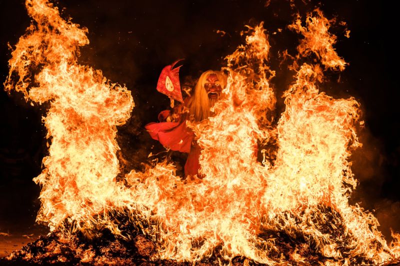 Японский дух огня проходит сквозь языки пламени костра