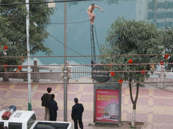 Китайская полиция сбила с опоры ЛЭП голого бомжа