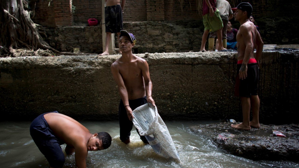 Молодые венесуэльцы ищут металл в реке