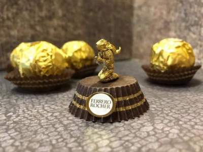 Золотистые фигурки знаков Зодиака из упаковки от конфет. Фото