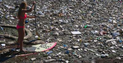 Бесстрашная серфингистка погружается в кучи мусора. Фото