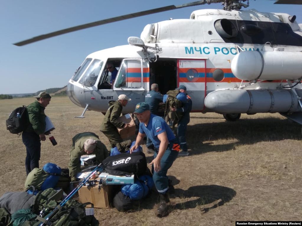 Команда спасателей перед вертолетом