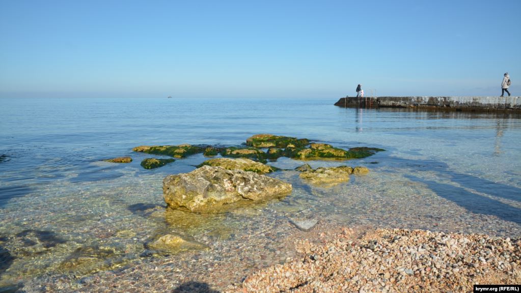 Морские камни на пляжном мелководье ждут летнего сезона, когда по ним начнут лазить дети