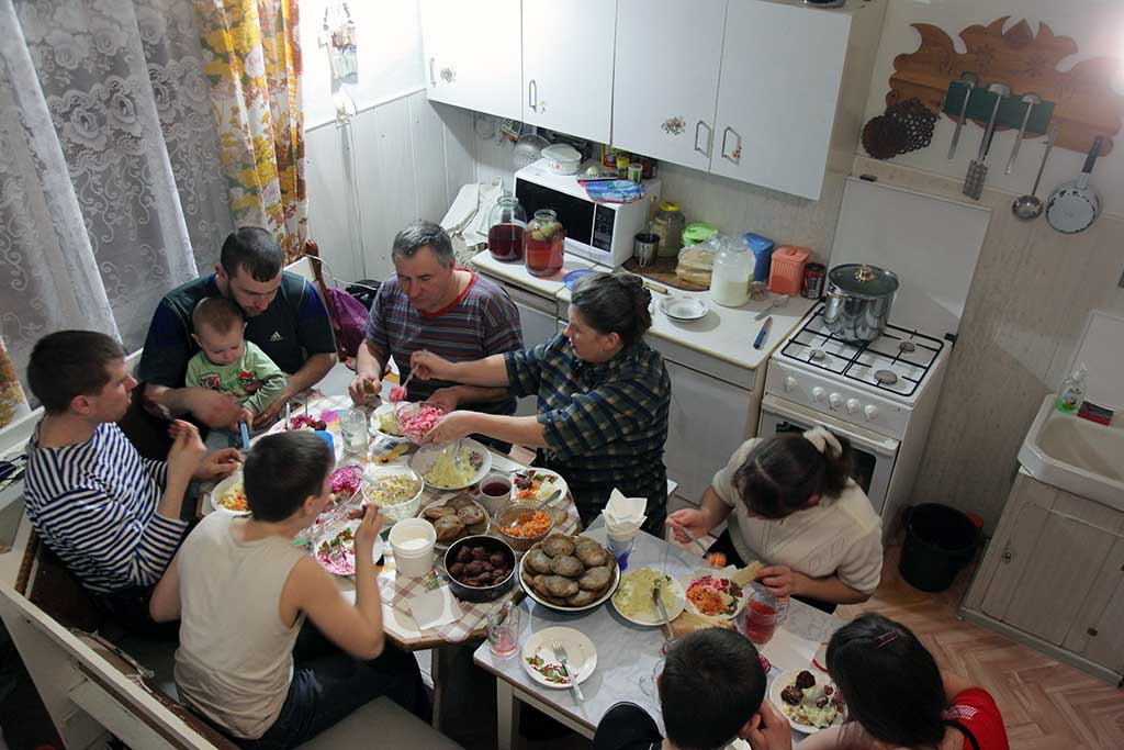 Дома гости есть. Застолье в квартире. Застолье с родственниками. Гости в квартире. Большая семья за столом в квартире.