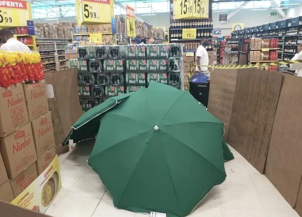 Когда сотрудник магазина умер, его прикрыли зонтами и продолжили работать. ФОТО