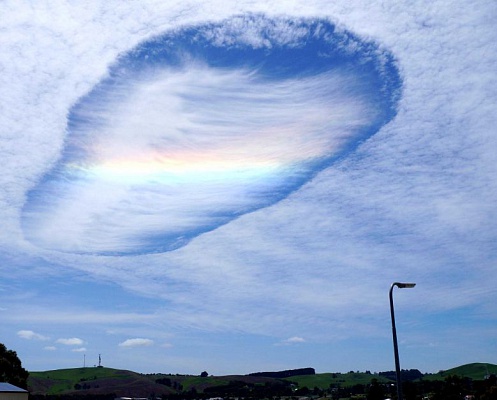 В небе над Австралией ученые зафиксировали «дырявое облако» с радугой внутри