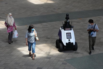 Робот следит за сингапурцами и туристами.